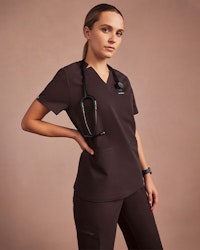 Woman wearing espresso colored scrubs.