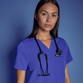 healthcare working wearing galaxy blue scrub top standing against blue background