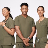 group of healthcare workers wearing matching dark olive scrubs