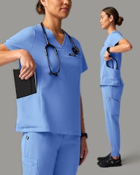 Women wearing blue scrubs and putting items in her pocket.