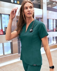 Woman wearing Midnight Green Scrubs walking.