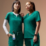 two women wearing hunter green scrubs