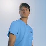 healthcare worker standing outside in the sun wearing light blue scrubs with sunny sky background