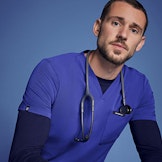 healthcare worker sitting down wearing galaxy blue scrubs and underscrub